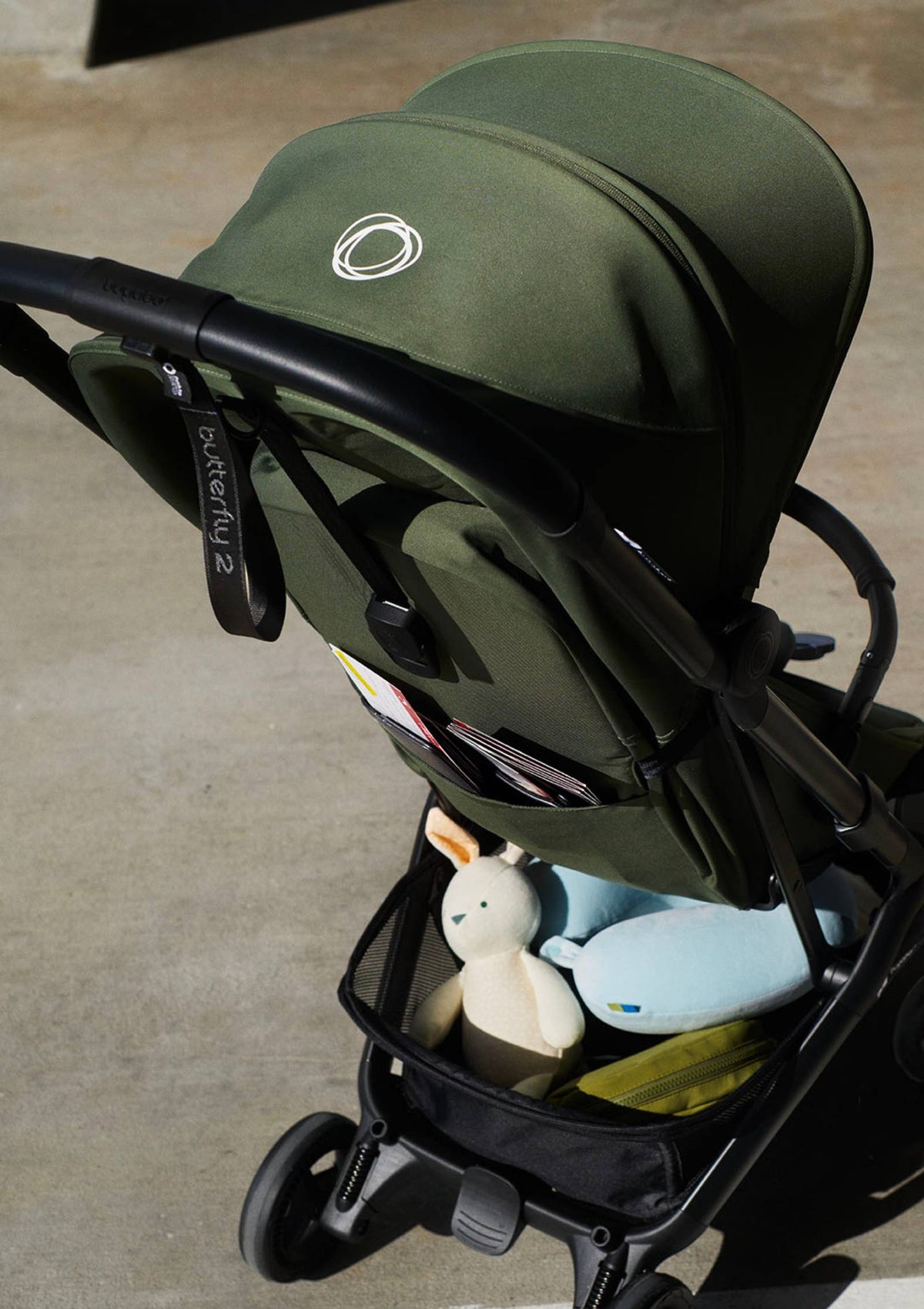 Bugaboo Buggy 'Butterfly 2' Waldgrün – Sitztasche und Einkaufskorb mit Essentials gefüllt