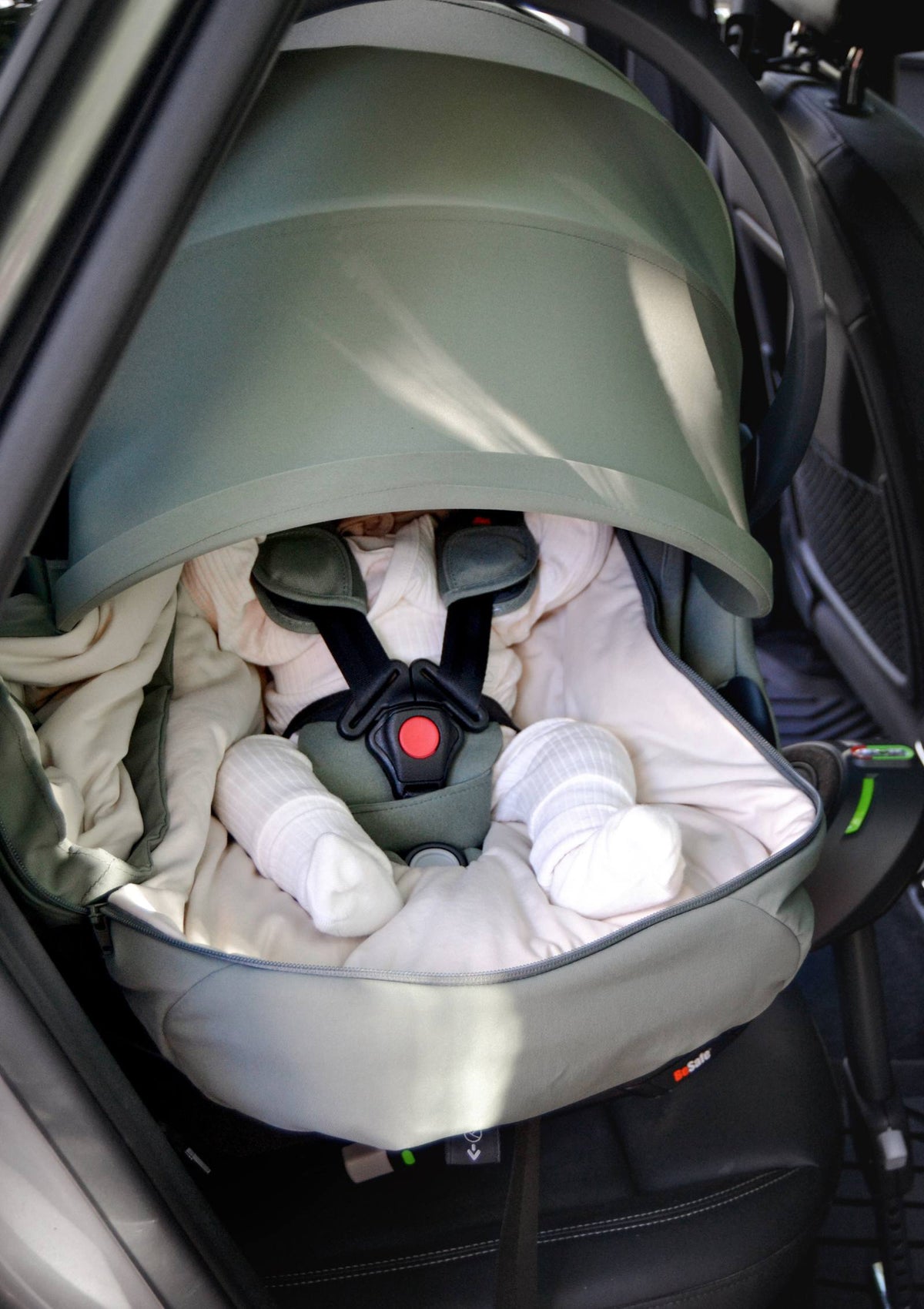 Baby im Fahrzeug in BeSafe Go Beyond, ausgestattet mit BeSafe Wind & Weather Cover für Babyschale 'Go Beyond' Meadow Green
