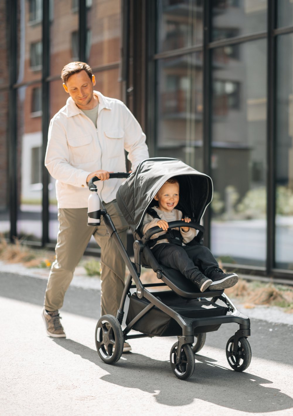 Mann schiebt Kind in Thule Sportwagen 'Sleek 2' Black