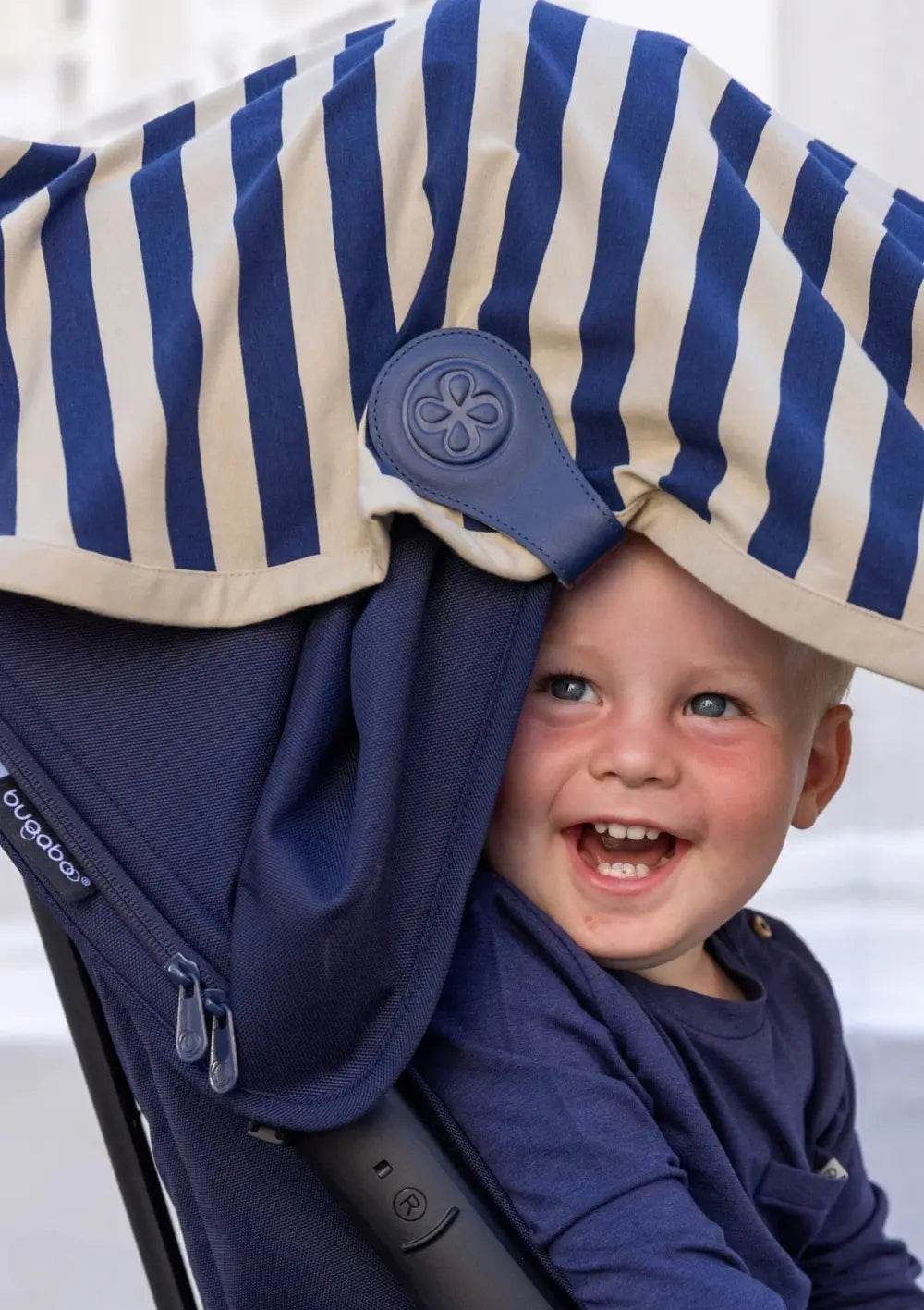 Cloby Multifunktionale UV-Decke UPF 50+ Navy Stripe mit 2er-Set Magnet-Clips Leder Navy Blue am Kinderwagen befestigt – Junge sitzt sonnengeschützt im Kinderwagen