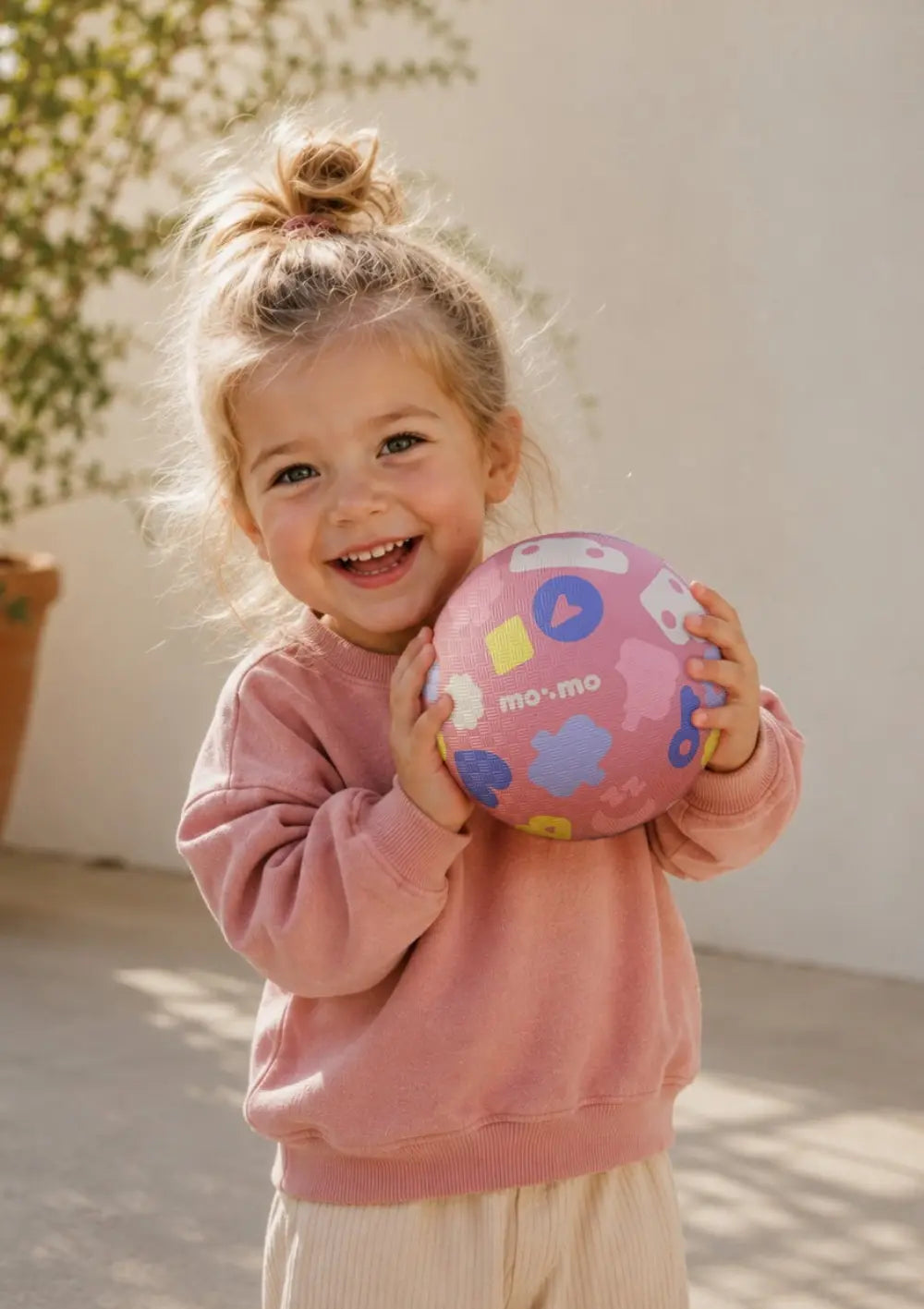 Mädchen spielt mit dem Ball aus dem mo:mo Starter-Set 'Bouncing Buddy' Spielball mit App-Zugang Candy