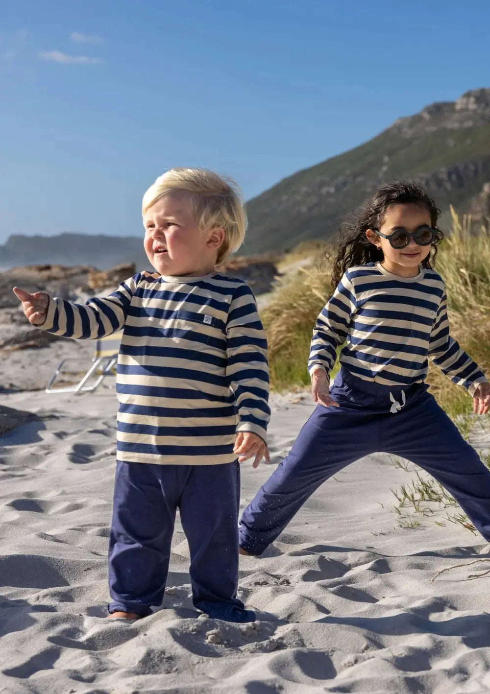 Kinder spielen am Strand – bkleidet mit Cloby Jogginghose UPF 50+ Navy und Langarmshirt UPF 50+ Navy/Sandy Stripe